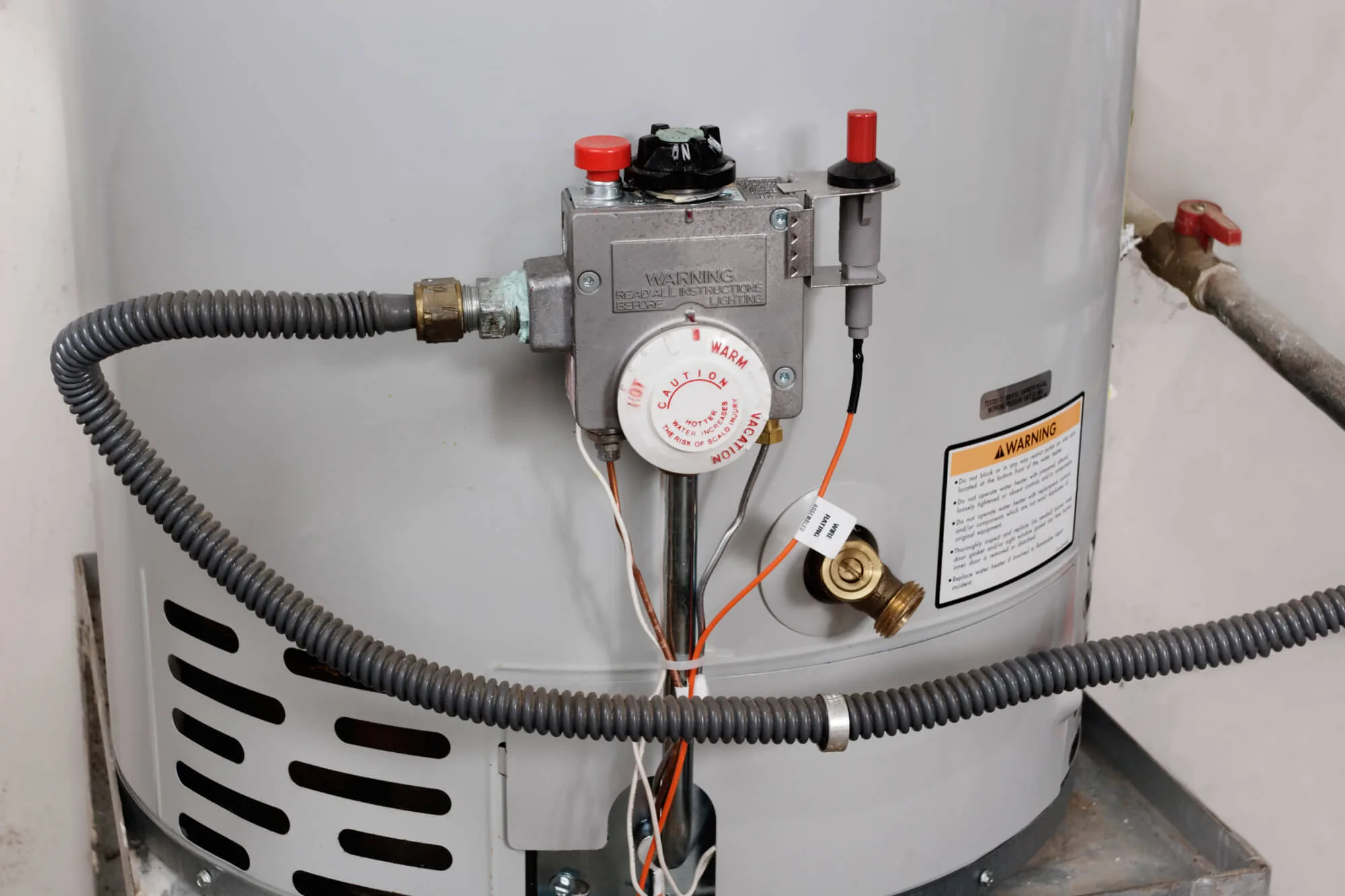 Gas water heater connection and controls in a household utility area