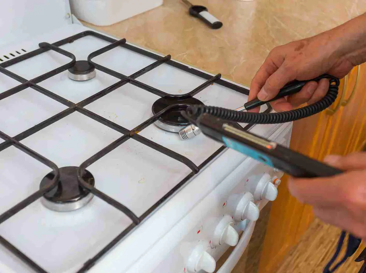 Gas cooktop with a safety testing device near its burners